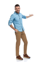 handsome bearded man with hand in pocket welcoming and inviting to side