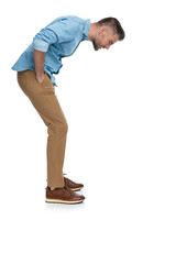 middle aged man with hands in pockets looking down