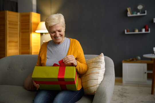 Elderly woman holding presents gift box package