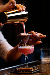 Fototapeta na wymiar Barman is making cocktail at night club.