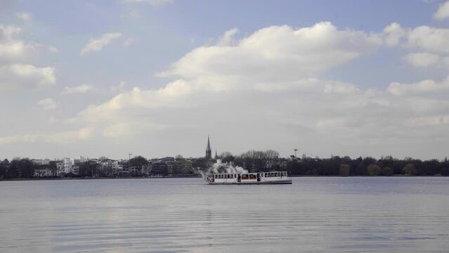 Barkasse boat on empty Alster Lake in Hamburg Germany against blue sky. Tourist attraction. 4K