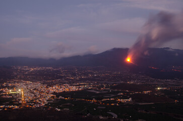 Naklejka na ściany i meble Volcanic eruption of Cumbre Vieja next to the village of Los Llanos de Aridane at sunset. La Palma. Canary Islands. Spain.