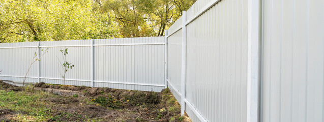 Outdoor garden fence building, new installed base frame with supports for a new metal fence in...