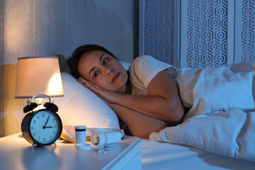Mature woman suffering from insomnia in bed at night - obrazy, fototapety, plakaty