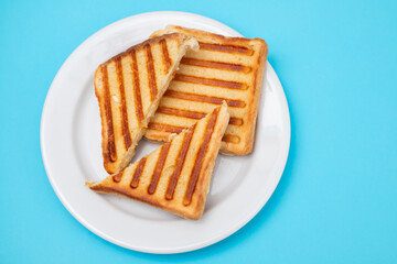 fresh breakfast toasts on white plate on blue