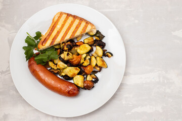fried sausage with vegetables and toast on plate