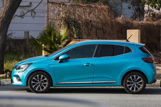 Side; Turkey – February 18 2022:   blue  Renault Clio  is parked  on the street on a warm summer day against the backdrop of a  park