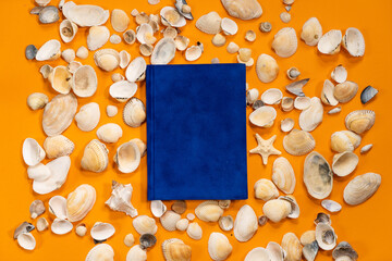 Notepad, shell and seashells on orange background for mockup. Relax beach summer sea concept. Plans for summer to do list
