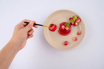 Hand and jelly dessert with Fresh organic Carunda or Karonda fruits on white background