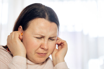 Young woman suffering from tinnitus disease of civilization, healthcare concept