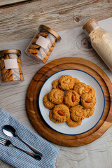 Homemade almond cookies in ceramic white plate on wood table background.