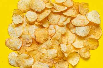 Close-up of potato chips or crisps in bowl against yellow background