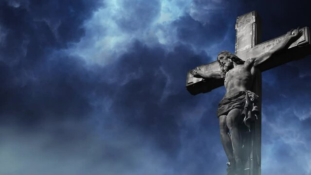 statue of jesus on the cross on a dark cloud background.