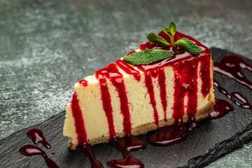Piece of cheesecake with fresh strawberries jam and mint. Tasty homemade cheesecake