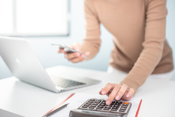 financial adviser working with calculator at office. accountant doing accounting and calculating revenue and budget. bookkeeper making calculation. finance and economy concept. online shopping.