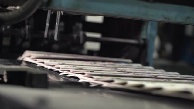Printed newspapers are moved along conveyor. Printing house. Printed publications, newspapers fall on conveyor belt and move along it. Media, article, daily news, print edition, journalism, politics