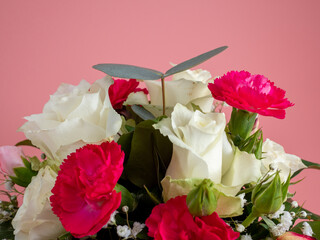 Basket of flowers on a pink background. Beautiful bouquet of flowers.
