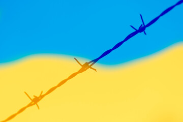 barbed wire and colors of ukrainian flag as symbol for refugees by russian invasion in Ukraine