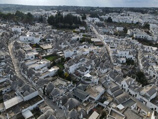 Aerial view of Alberobello, city of Trulli in Itria Valley, Puglia. Traditional Apulian dry stone huts with a conical roof in the Murge area of the Italian region of Apulia. Trulli city in south Italy