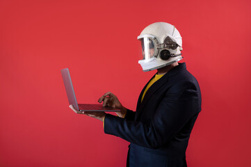 Businessman with astronaut helmet using a laptop