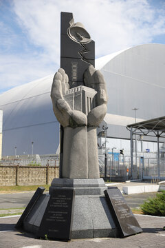 Monument to the casualties of the Chernobyl disaster in front of the New Safe Confinement in Chernobyl Exclusion Zone, Ukraine