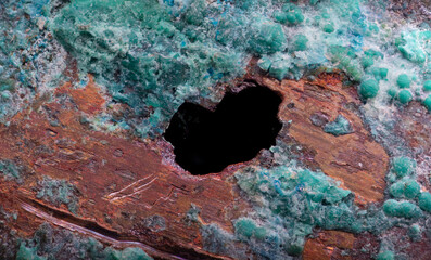 Close-up of pitting corrosion on a copper pipe causing a water leak
