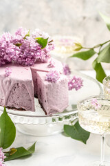 Delicious berry mousse cake, with prosecco, champagne, wine, bouquet of purple blooming lilacs, French cuisine, postcard, background
