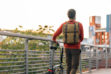 Man Carrying Folding Bicycle in the Street