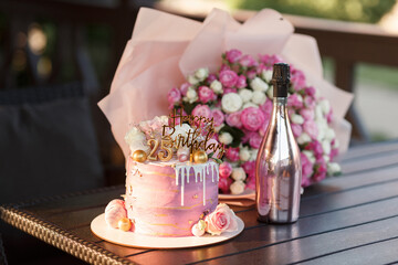 beautiful layered pink cake with golden numbers on a wooden stand twenty five years birthday for a...