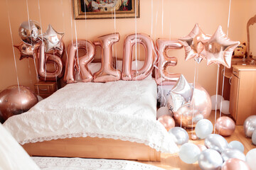 bride's young girl's room decorated with shiny balloons of various shapes and an inscription in...