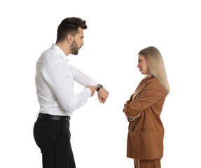 Businessman pointing on wrist watch while scolding employee for being late against white background