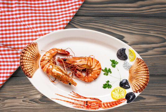 Closeup Of Fresh Grilled Large Tiger Prawns Or Shrimps On A Colourful Plate Of Seafood On Rustic Table With Plaid Cloth. Healthy Food Concept. BBQ. Seafood Background. Space Advertising.