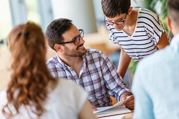 Happy university students studying with books in library. Group of multiracial people in college