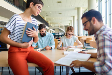 Happy group of students studying and working together in a college library
