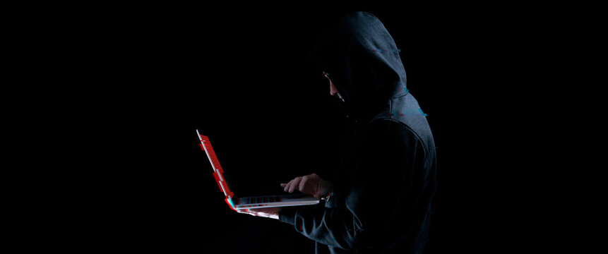 Hacker attack cyber security. Digital laptop in hacker man hand isolated on black. Blurred Internet web hack technology with glitch effect. Login and password, cybersecurity banner concept.