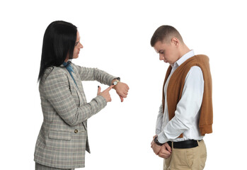 Businesswoman pointing on wrist watch while scolding employee for being late against white background