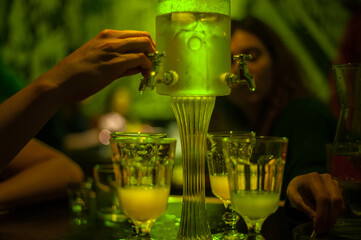 green absinthe drip fountain for a big company with four taps in a bar - obrazy, fototapety, plakaty