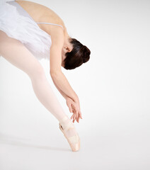 Nothing but elegance. Dedicated young ballerina dancing en pointe against a white background.