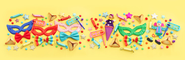 Purim celebration concept (jewish carnival holiday) over yellow background. Top view, flat lay