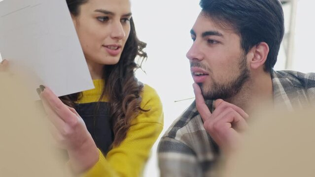 Couple moving house looking at blueprints