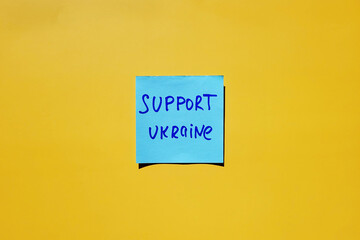 Blue stickers with words on yellow background close up. Flat lay. Concept of freedom and support Ukraine. Protest action. Stop war.
