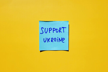 Blue stickers with words on yellow background close up. Flat lay. Concept of freedom and support Ukraine. Protest action. Stop war.