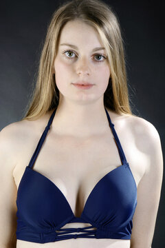 Gorgeous young woman posing in blue bikini in studio	