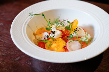 Salad with herbs, radishes and tomatoes. Side view.