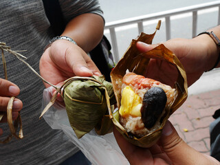 Chinese people and foreign travelers buy and eat Zongzi or chinese sticky rice dumpling from at local restaurant in Market Street Teochew old town at Chaozhou city capital urban in Guangdong, China