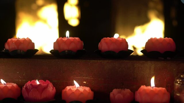Select lotus candle burn at temple. Background is furnace burn joss paper