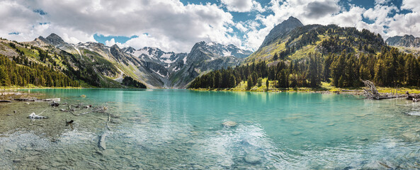 Atmospheric and moody panoramic landscape of scenic mountain lake at misty and cloudy day. National park and environmental ecology background