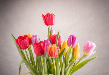 a big bouquet of tulips of various colours in crystal vase