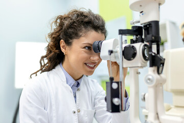 Eye doctor with female patient during an examination in modern clinic. Ophthalmologist is using...