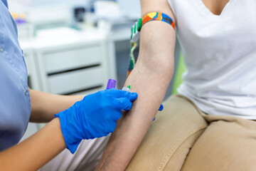 Obraz premium Medical technologist doing a blood draw services for patient. lab assistant with sterile rubber gloves taking blood sample from patient.